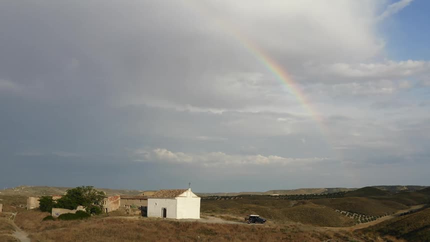A rainbow runs over the hills