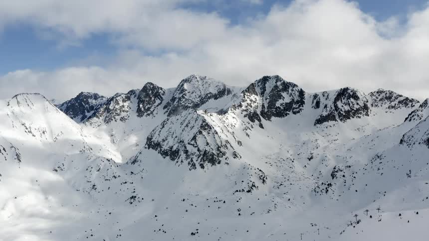 Snow covers a mountain range on a winter day
