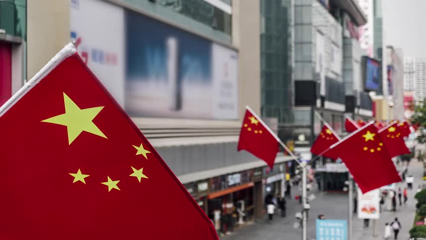 Time lapse of pedestrians walking on a street in china lined with flags