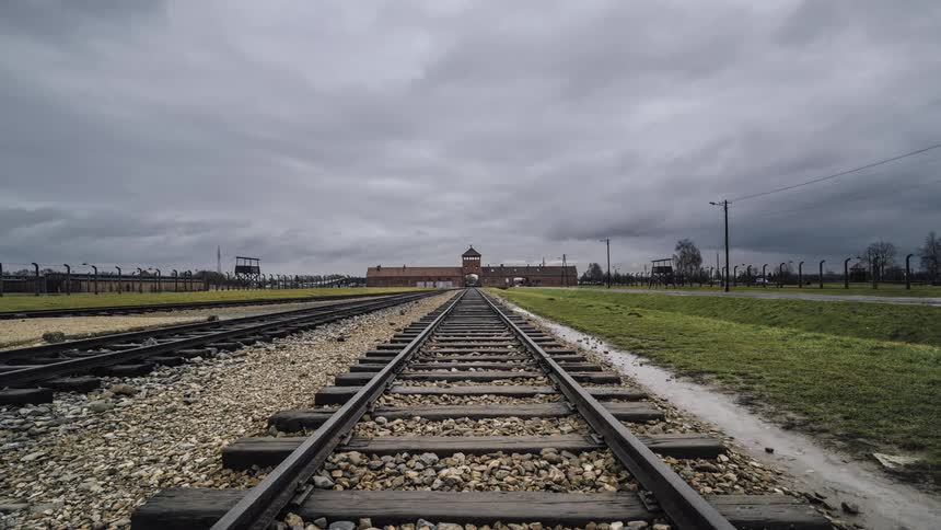 Time lapse of clouds moving over train tracks and a station
