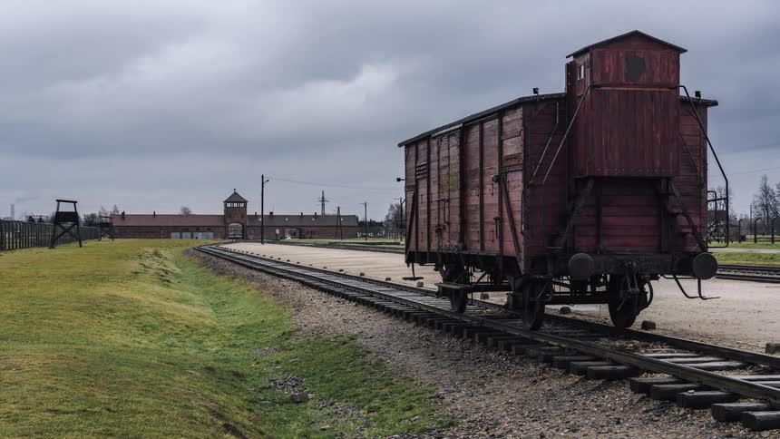Time lapse of clouds moving over a station and railway tracks with a rail car sitting on them
