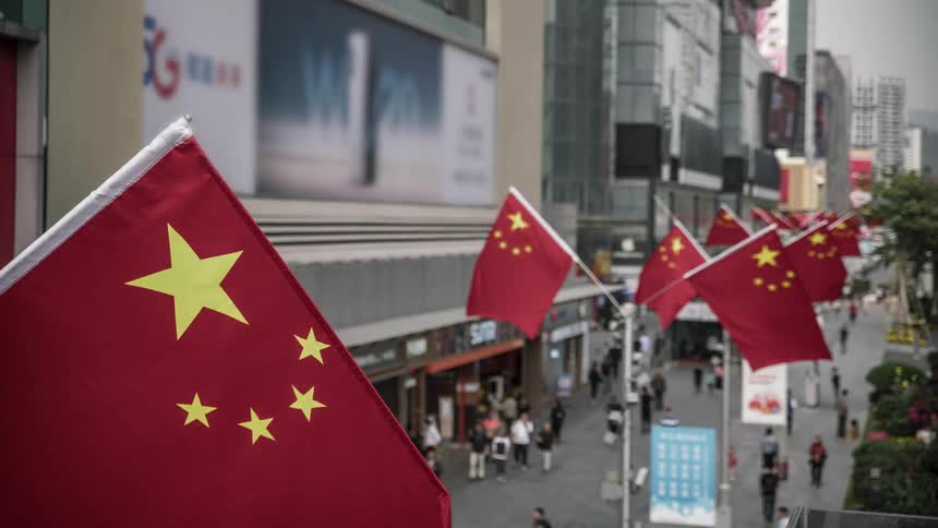 Time lapse of pedestrians on a busy street with chinese flags on lamp posts