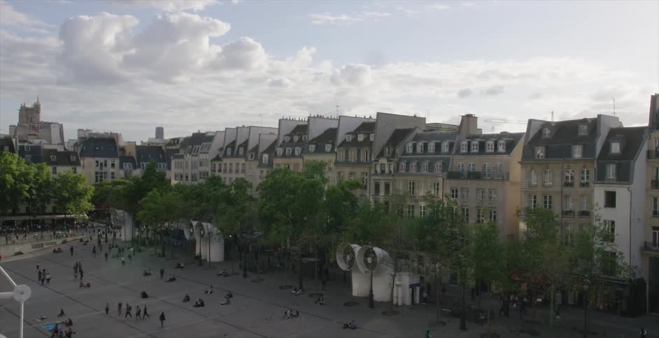 Aerial view of a square before a row of buildings with people all over