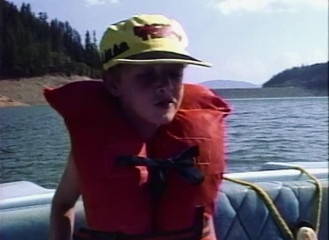 A child sits on the boat in the lake