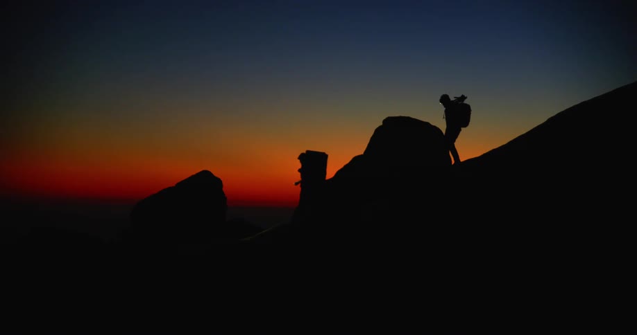Two people hiking down a hill at dusk