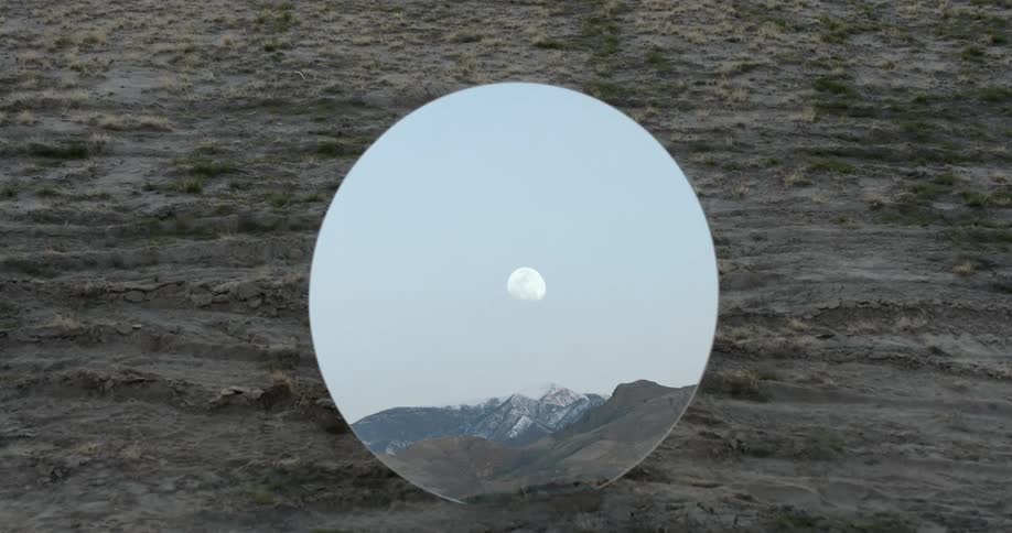 The moon hangs above the mountains in the mirror reflection