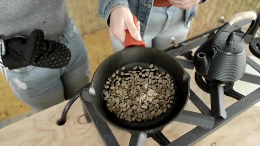 Two people are outdoors cooking during midday