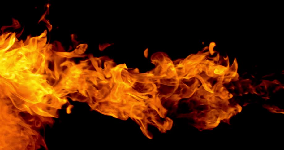 A flame burns in front of a black background