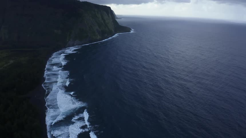 Oceans crash on a shoreline beneath the cliffs
