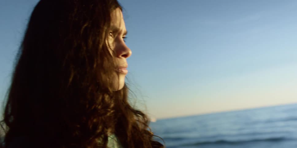 A woman watches the sunrise on the beach