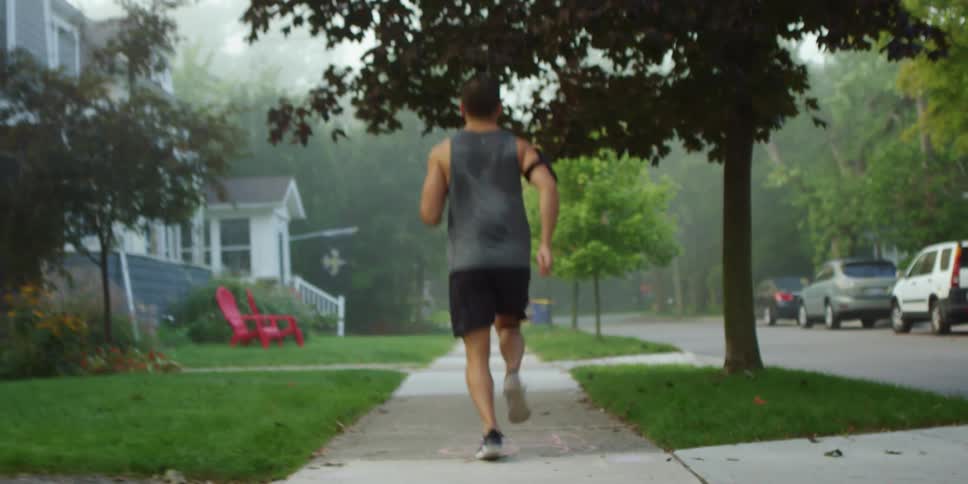 A man is jogging outdoors in a neighborhood