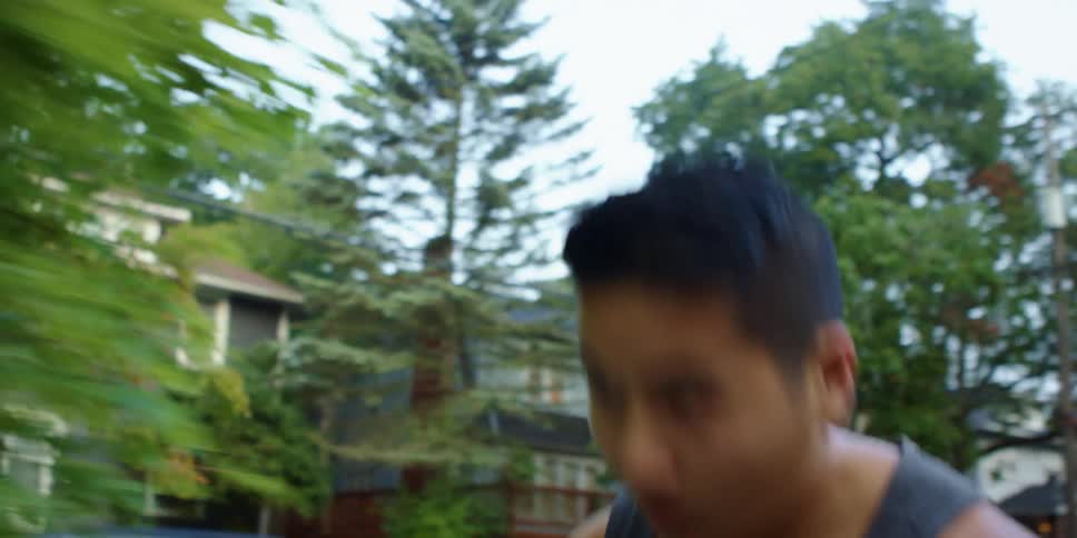 A man jobs in a suburban neighborhood with homes cars and lots of trees