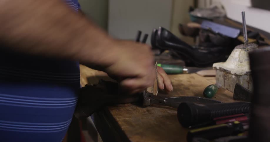A cobbler removing the sole from a boot