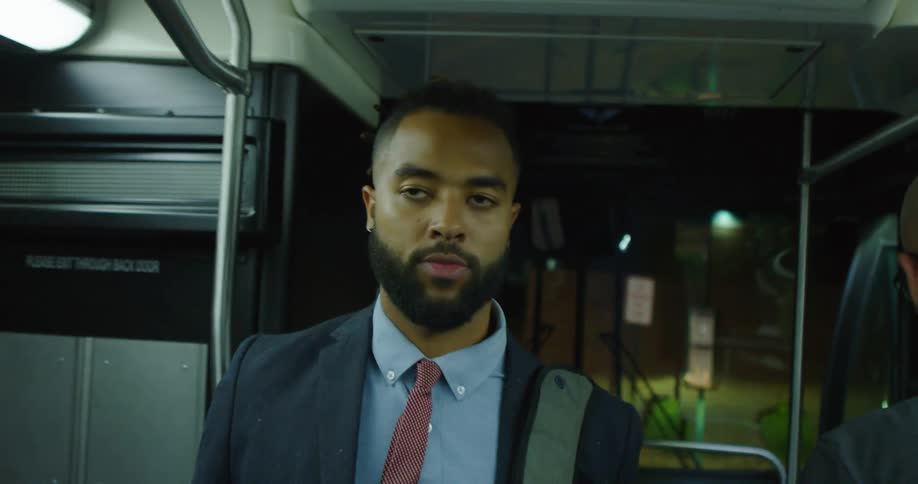 A man with a shirt and tie enters a bus with people