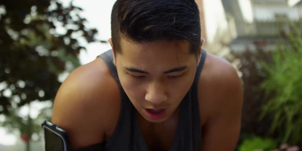 A man takes stops to catch his breath while working out outside
