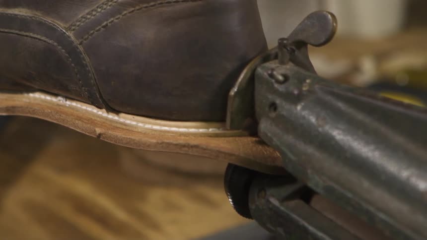 A person is repairing a shoe with a machine