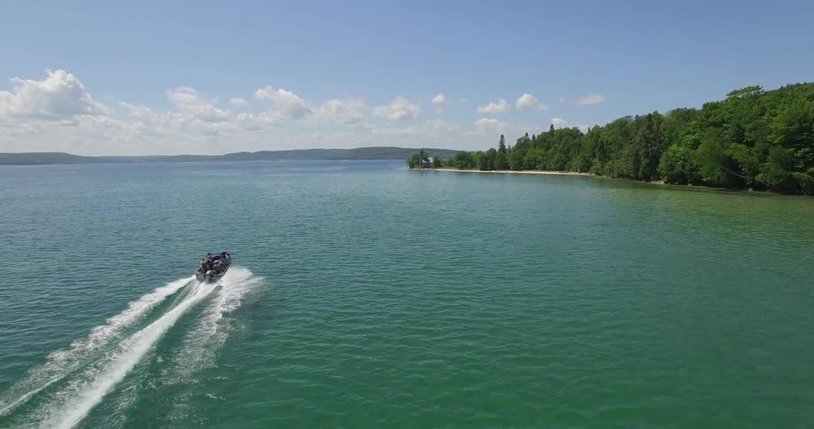 A boat full of people on a lake on a sunny day