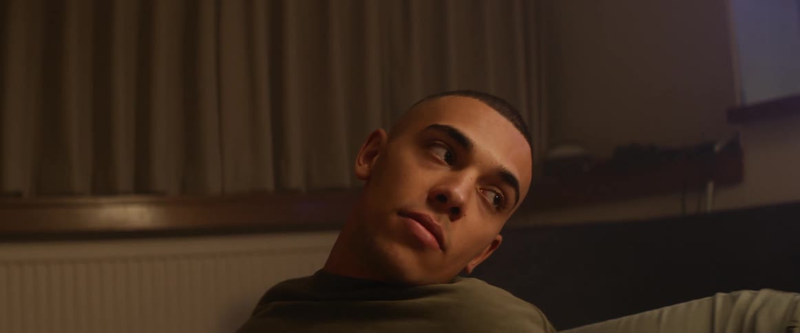 A man is relaxing in a bedroom and smoking a cigarette with another person