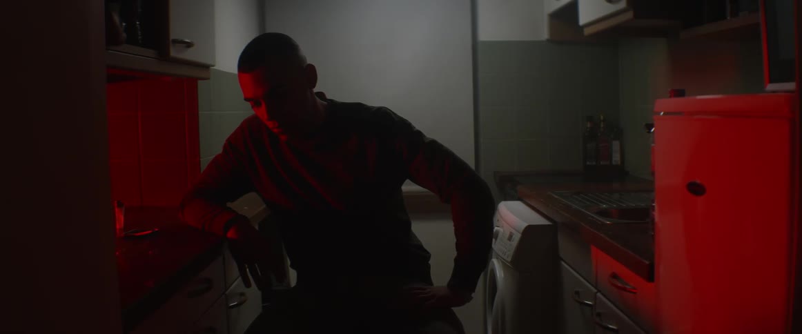 Man sits at a desk near a washing machine