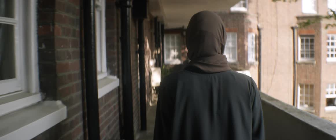 A woman is walking through a neighborhood in spring