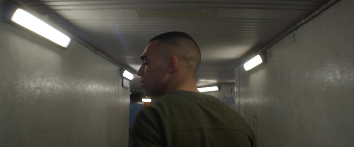 A man looks behind him as he walks down a hallway