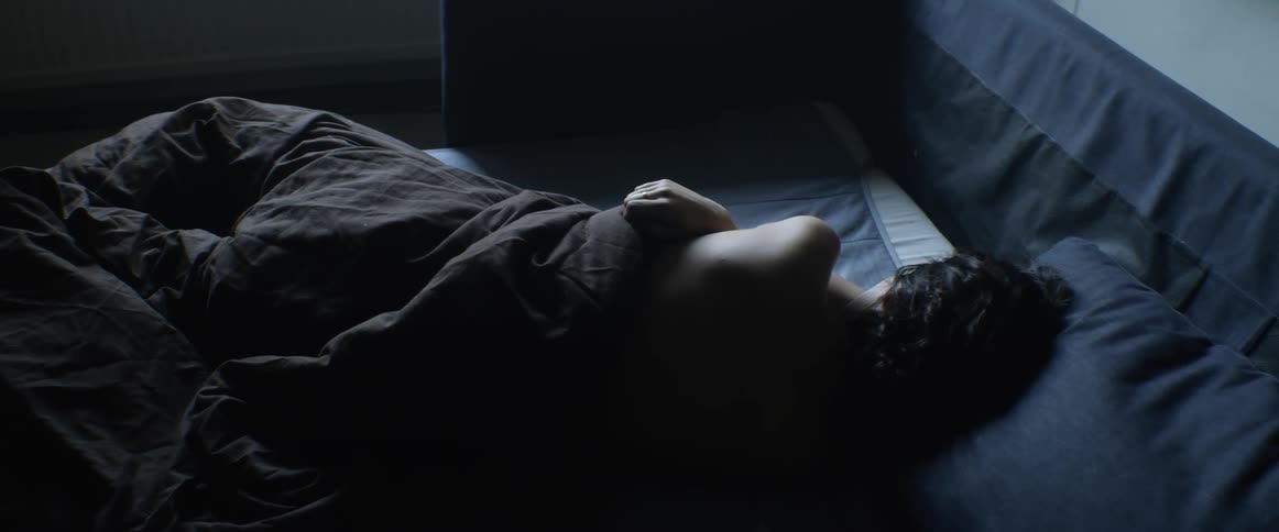 Blanket lays on a person sleeping in a bed