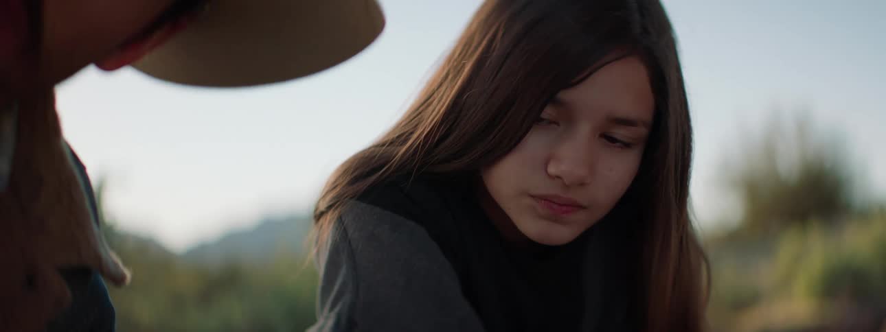 A girl watches a man work on something
