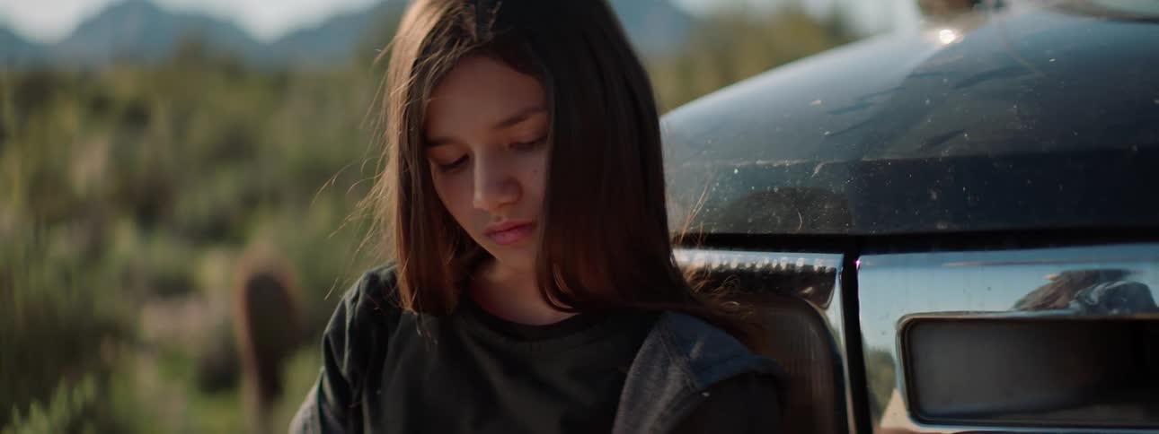 A girl is reading a book by the truck