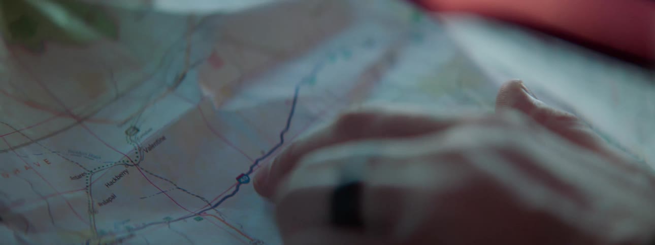 Fingers point to a location on a map