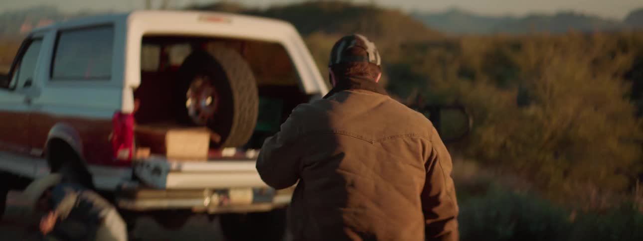 People are changing the tire on a vehicle on the side of the road