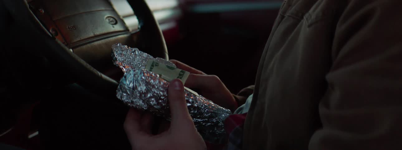 Man sitting in car discovers dollar bills inside an aluminum foil wrap