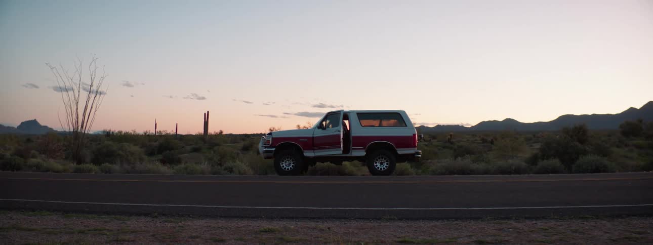 A truck is parked in a rural area at dusk