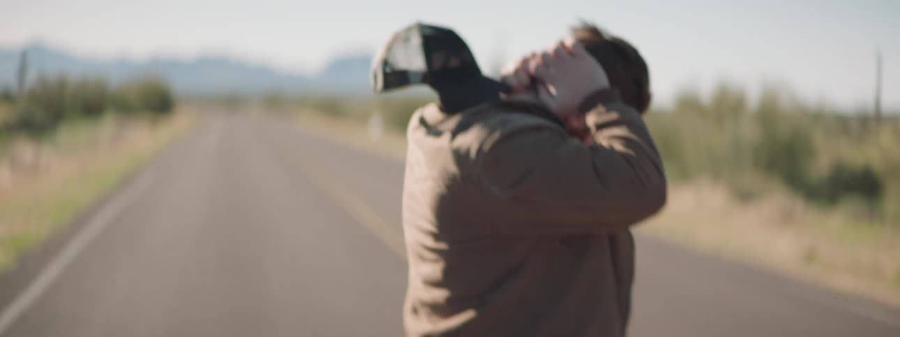 A man exits his vehicle to walk on the road