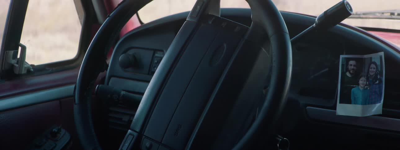 A picture of a family is displayed on the dashboard of a car