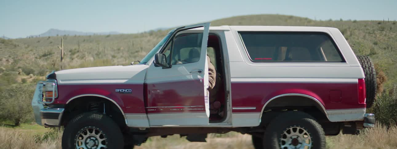 A man sitting in his truck jumps out and starts waving his arms in the air