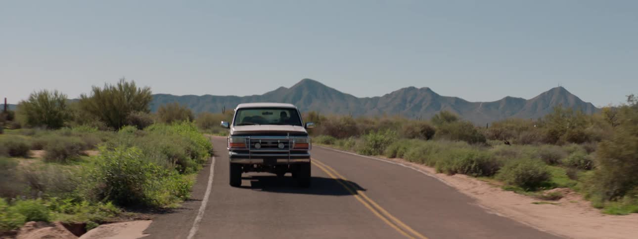 Pickup truck drives on a country road on a sunny day