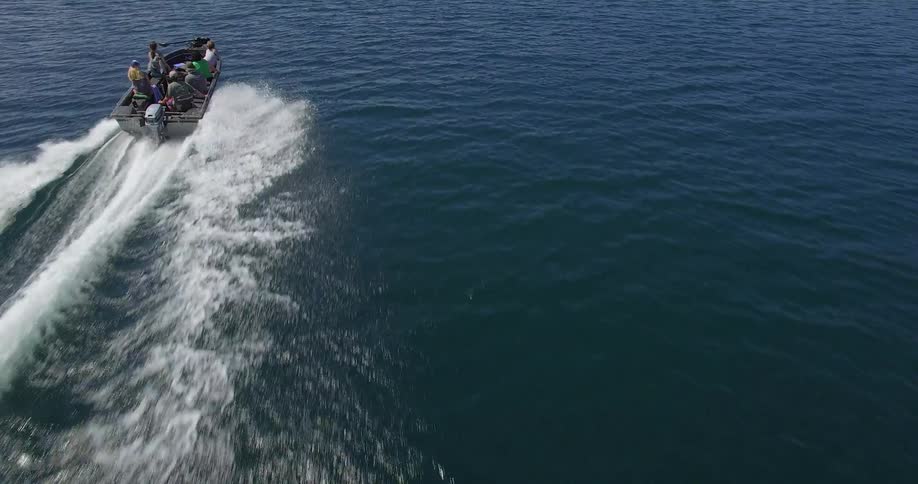 A boat travels through the water during the day