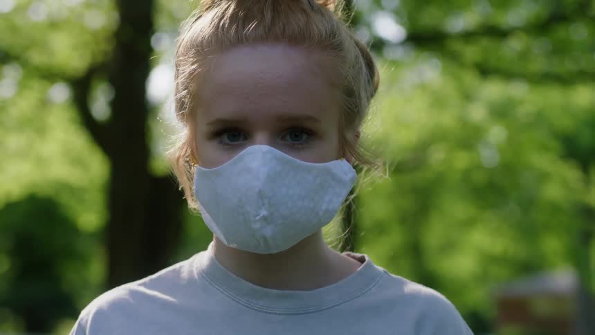 A girl is wearing a mask in the forest