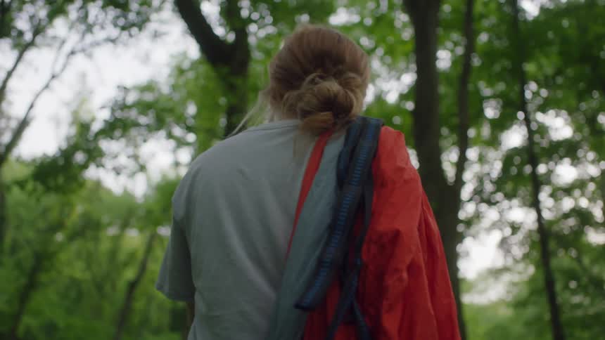 A woman is hiking through a forest