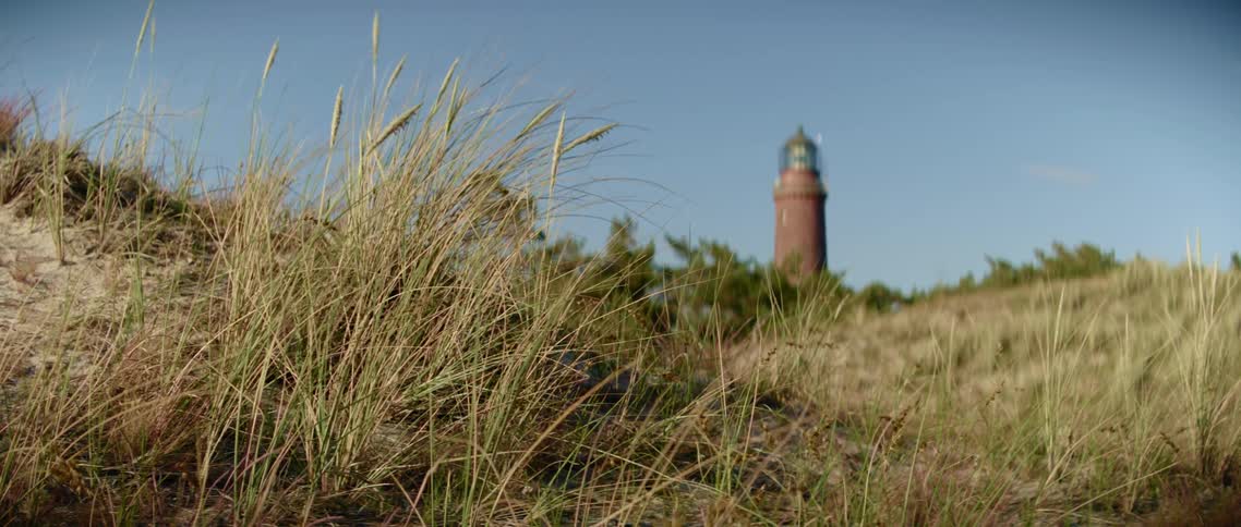 A lighthouse on the edge of a hilly field
