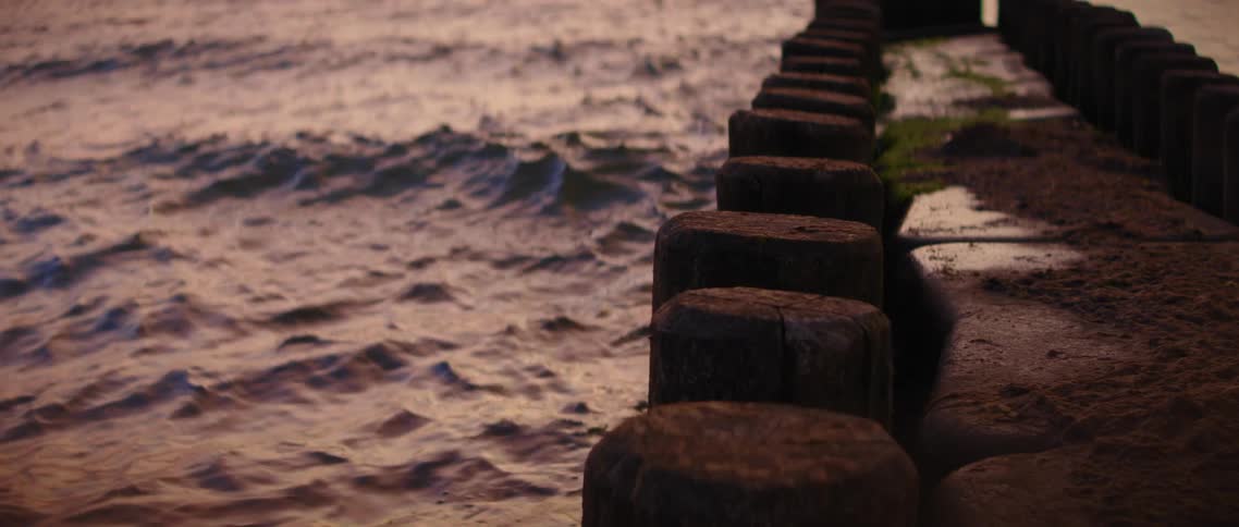 A stone walkway over the ocean in the evening