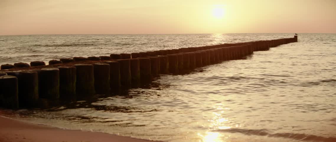 The sun over a pier in the water
