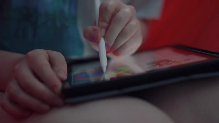 A child is drawing on a tablet