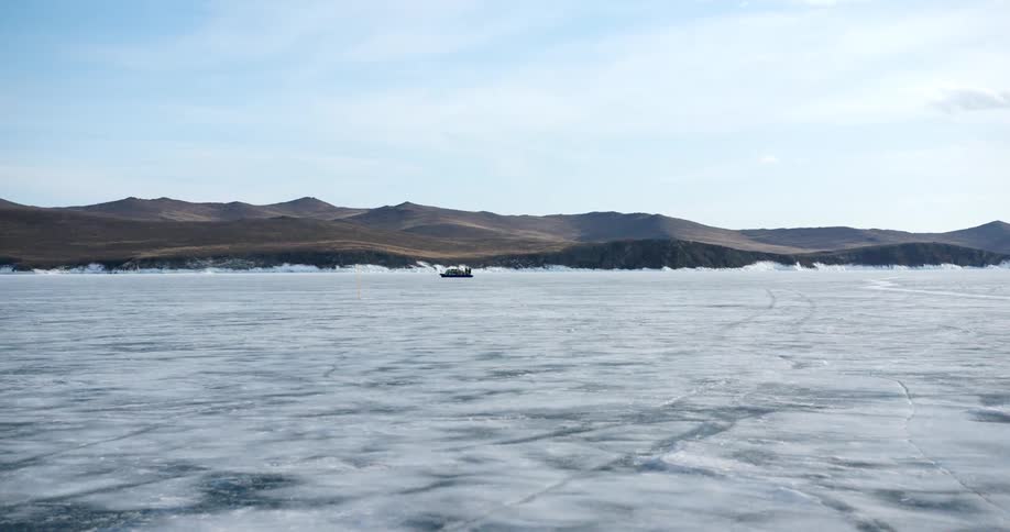 A boat travels across a frozen body of water