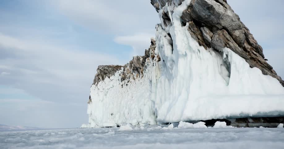 A rock promontory covered in ice near the frozen surface of the ocean