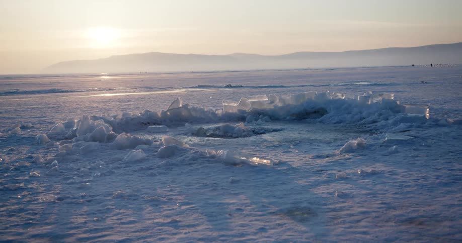 The sun sets over a snowy arctic landscape