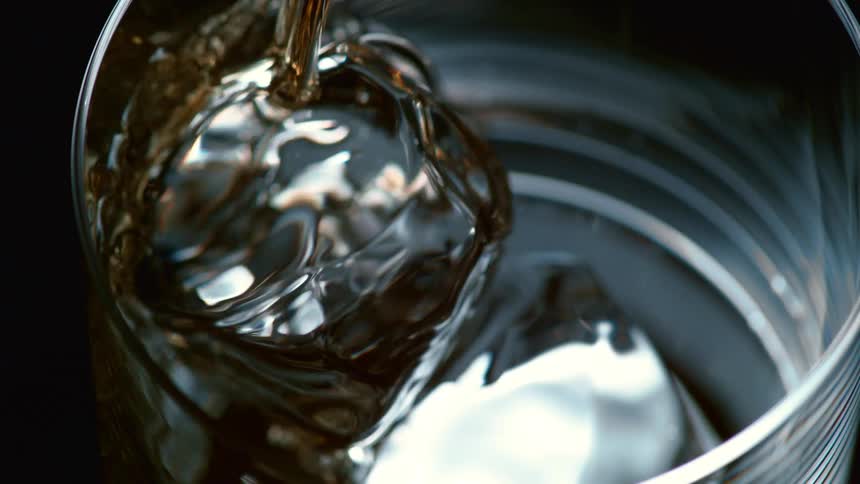 Liquor poured into a glass with ice cubes