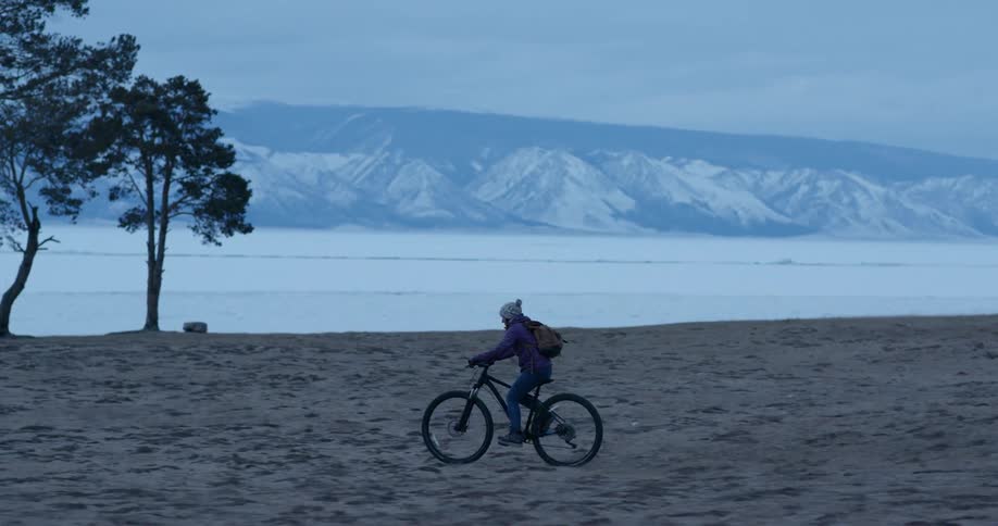 A person is riding their bicycle by the lake