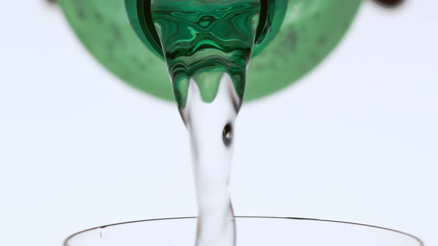 A person is filling a glass from a bottle