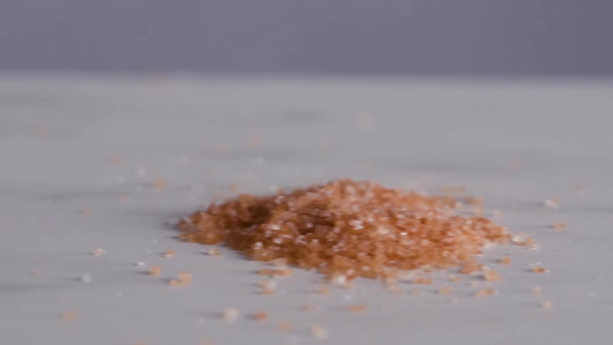 White crystals are piled onto surface next to salmon colored crystals